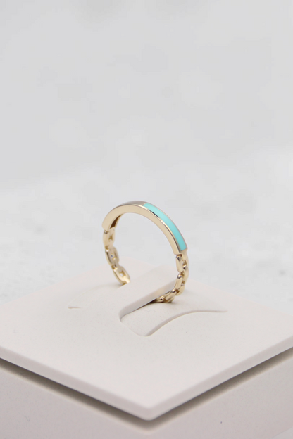 Zafrah 14k solid gold chain link ring with a smooth turquoise enamel inlay on a white display stand