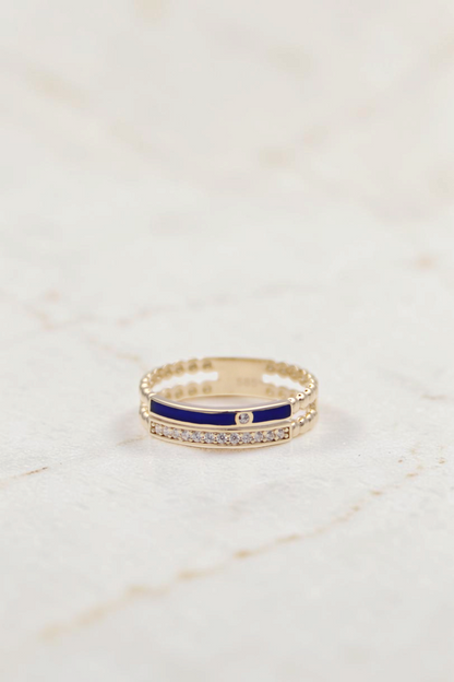 Zafrah 14k gold double band ring featuring a blue enamel stripe, clear stones, and beaded edges on a white background.