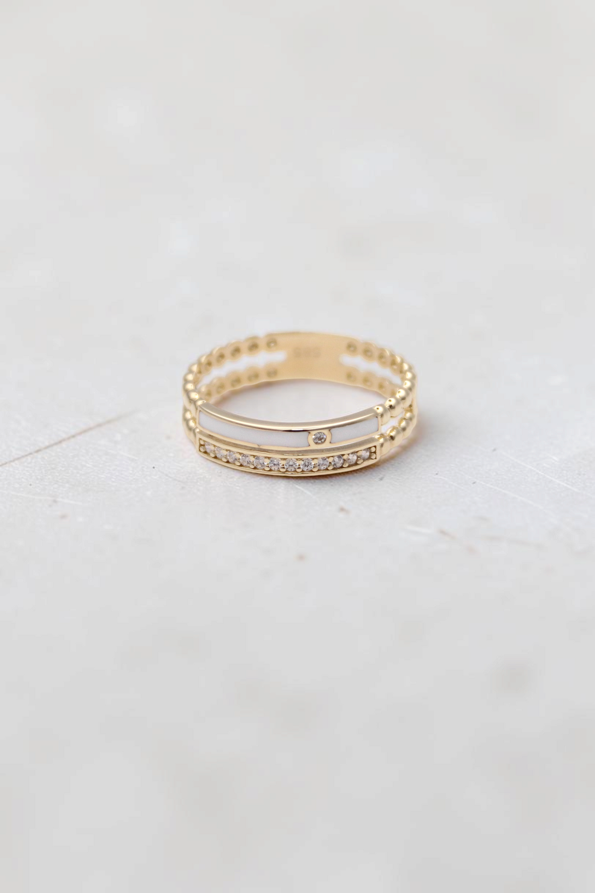 Zafrah 14k solid gold double beaded band ring featuring a clear stone and white inlay on a white background