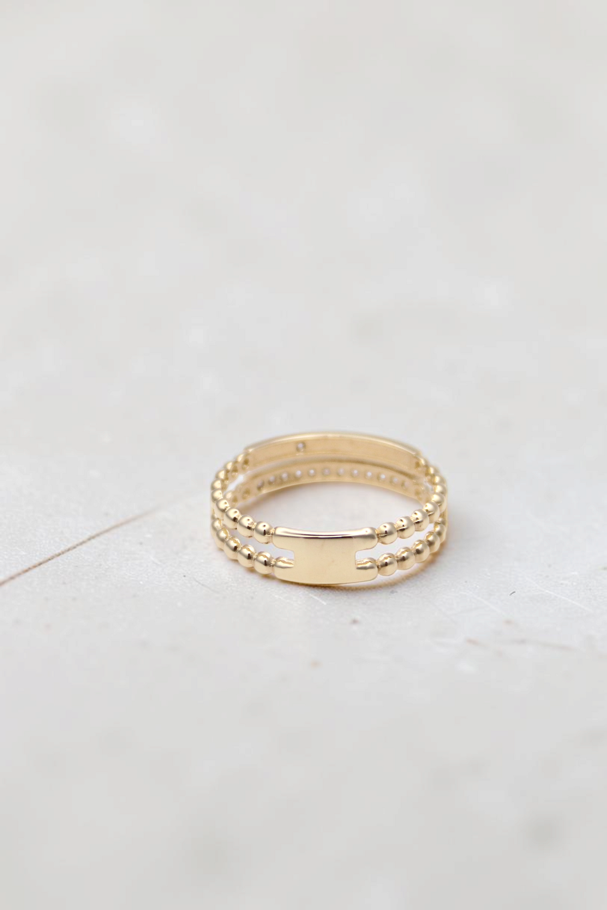 Zafrah 14k solid gold double beaded band ring featuring round clear stones and a smooth center bar detail.