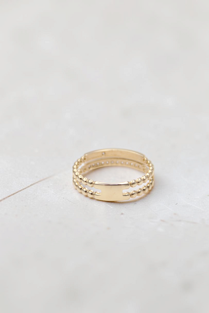 Zafrah 14k solid gold double beaded band ring featuring round clear stones and a smooth center bar detail.