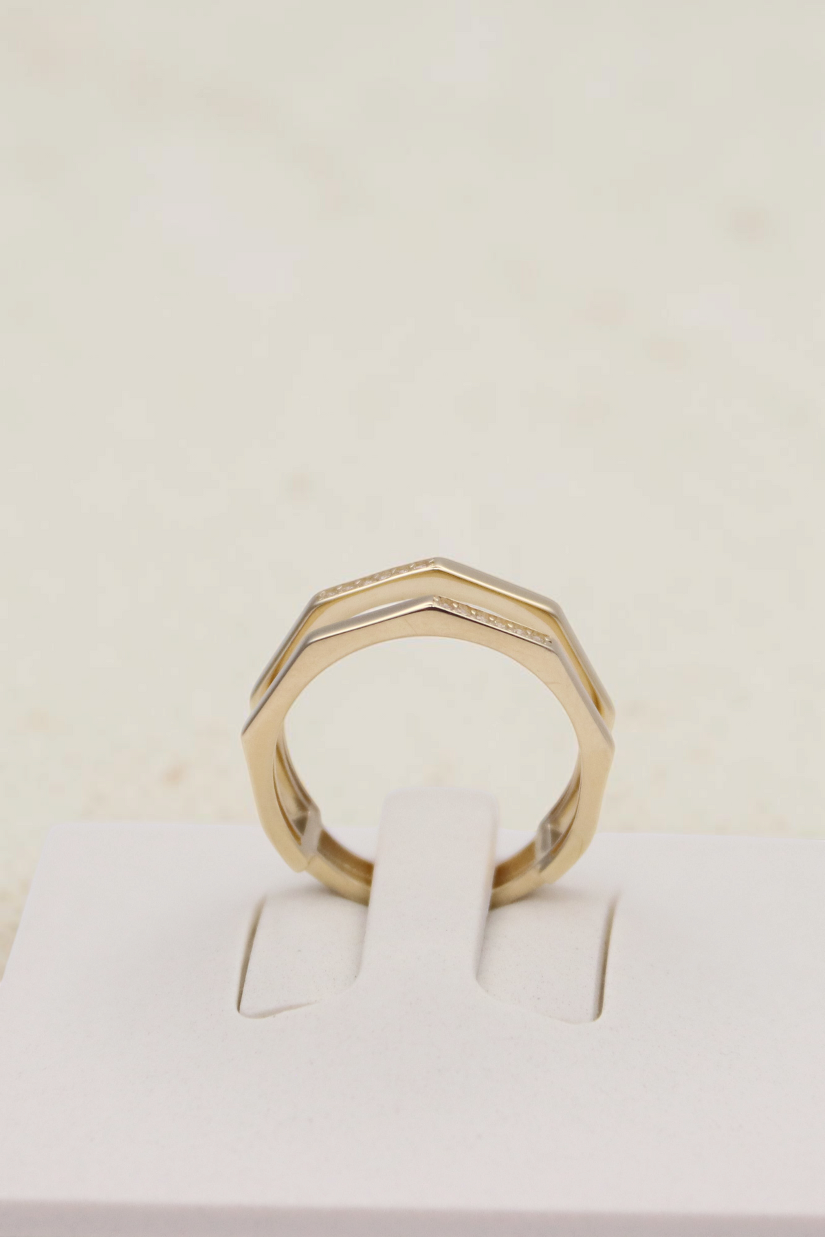 Zafrah double geometric band ring in solid 14k yellow gold with flat edges on a white display stand