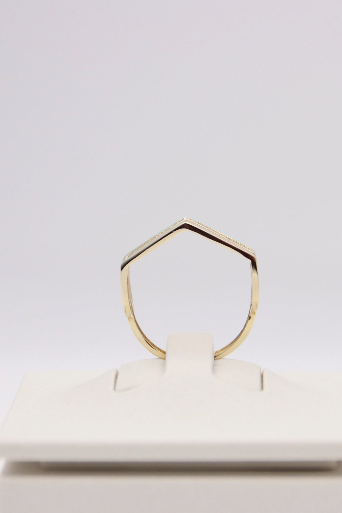 Zafrah 14k solid gold triple line ring with a pointed geometric design on a white display stand.