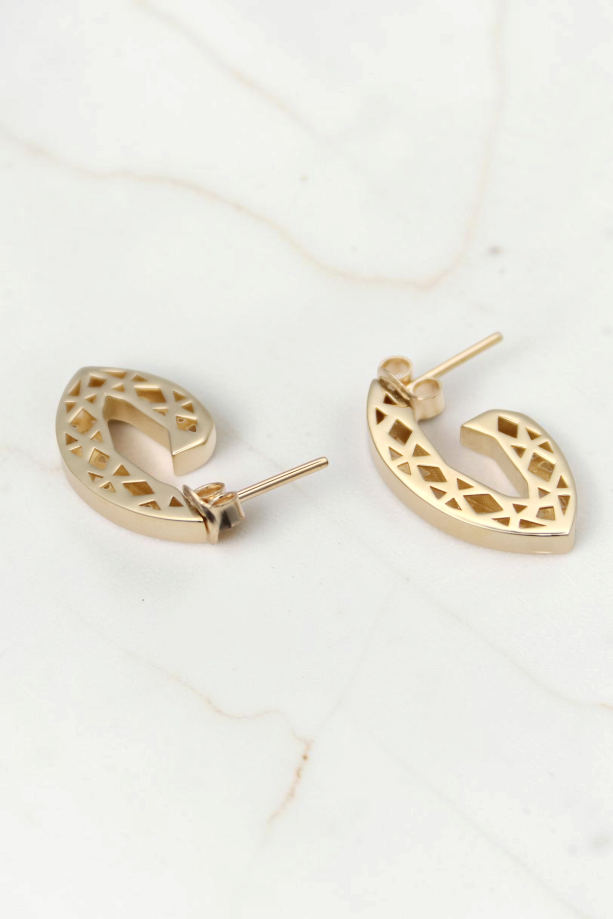 Zafrah 14k solid gold geometric triangle earrings with intricate cutout patterns on a white background