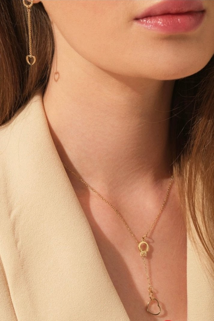 Zafrah 14k solid gold double heart drop pendant cable necklace worn by a model in a beige blazer.