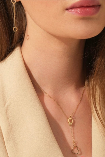 Zafrah 14k solid gold double heart drop pendant cable necklace worn by a model in a beige blazer.