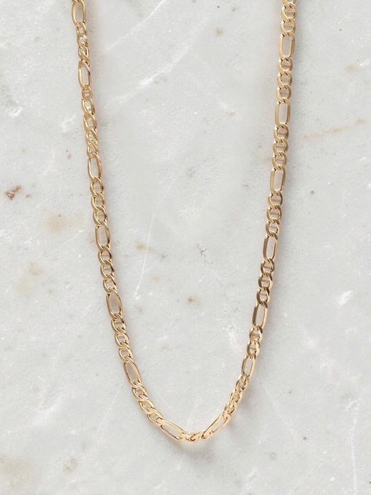 Zafrah 14k yellow gold Figaro chain necklace, 19.5 inches long with 4.5mm links on a white marble background.