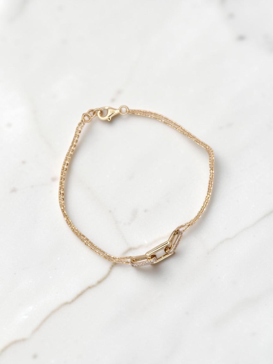 Zafrah 14k solid gold double cable bracelet featuring rectangle and oval links on a white marble background.