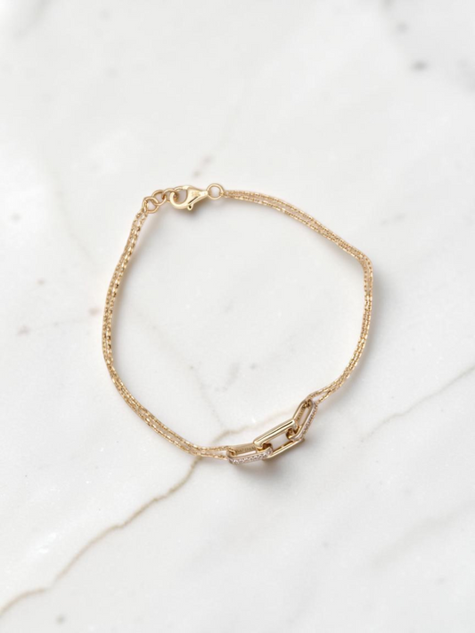 Zafrah 14k solid gold double cable bracelet featuring rectangle and oval links on a white marble background.
