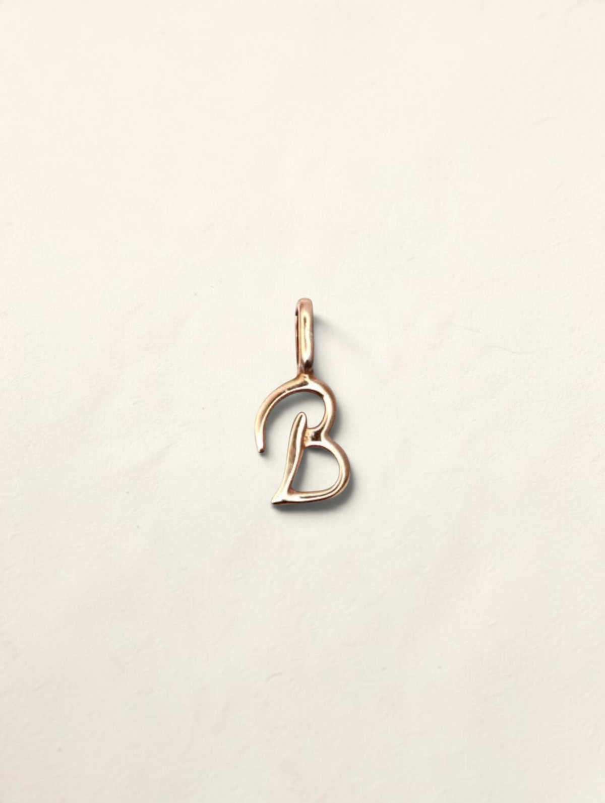 Zafrah 14K yellow gold initial B pendant with a polished finish on a neutral background