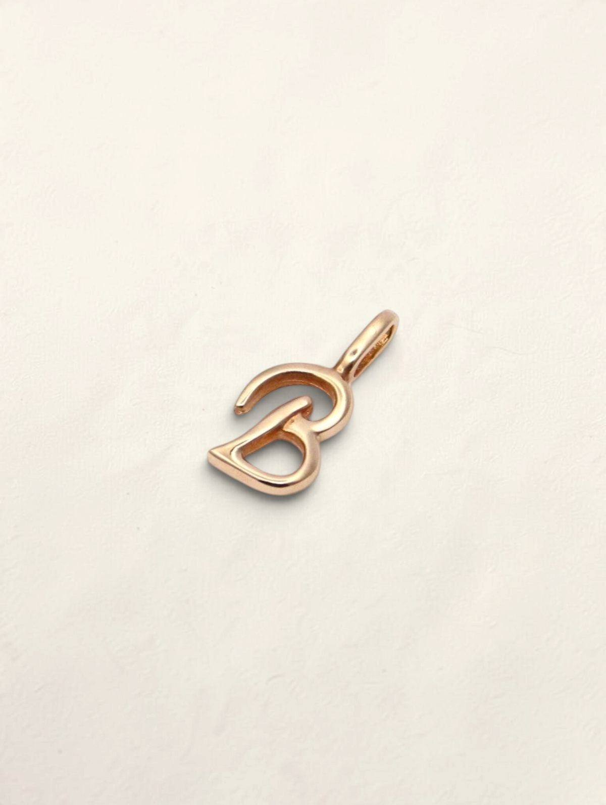 Zafrah 14K yellow gold initial B pendant with a polished finish on a neutral background