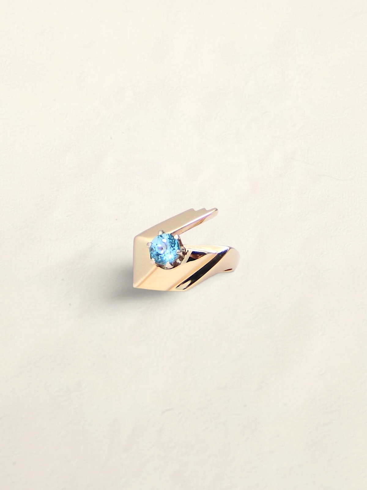 Zafrah 14k yellow gold abstract ring featuring a 1ct round blue topaz stone on a minimalist geometric band