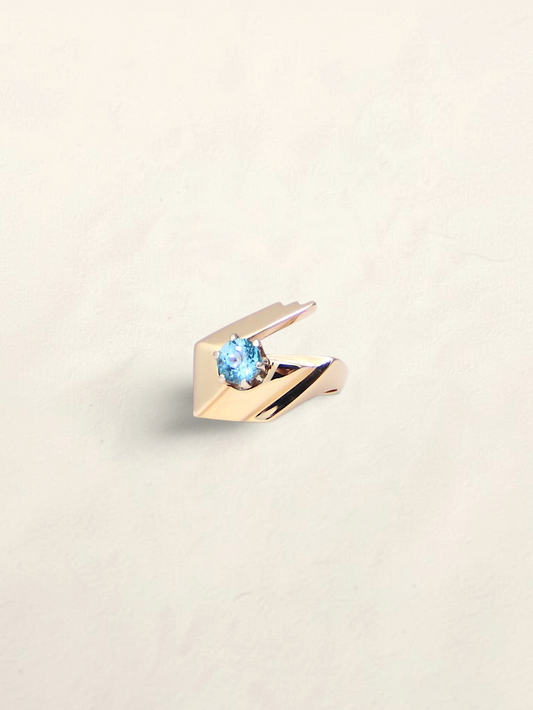 Zafrah 14k yellow gold abstract ring featuring a 1ct round blue topaz stone on a minimalist geometric band