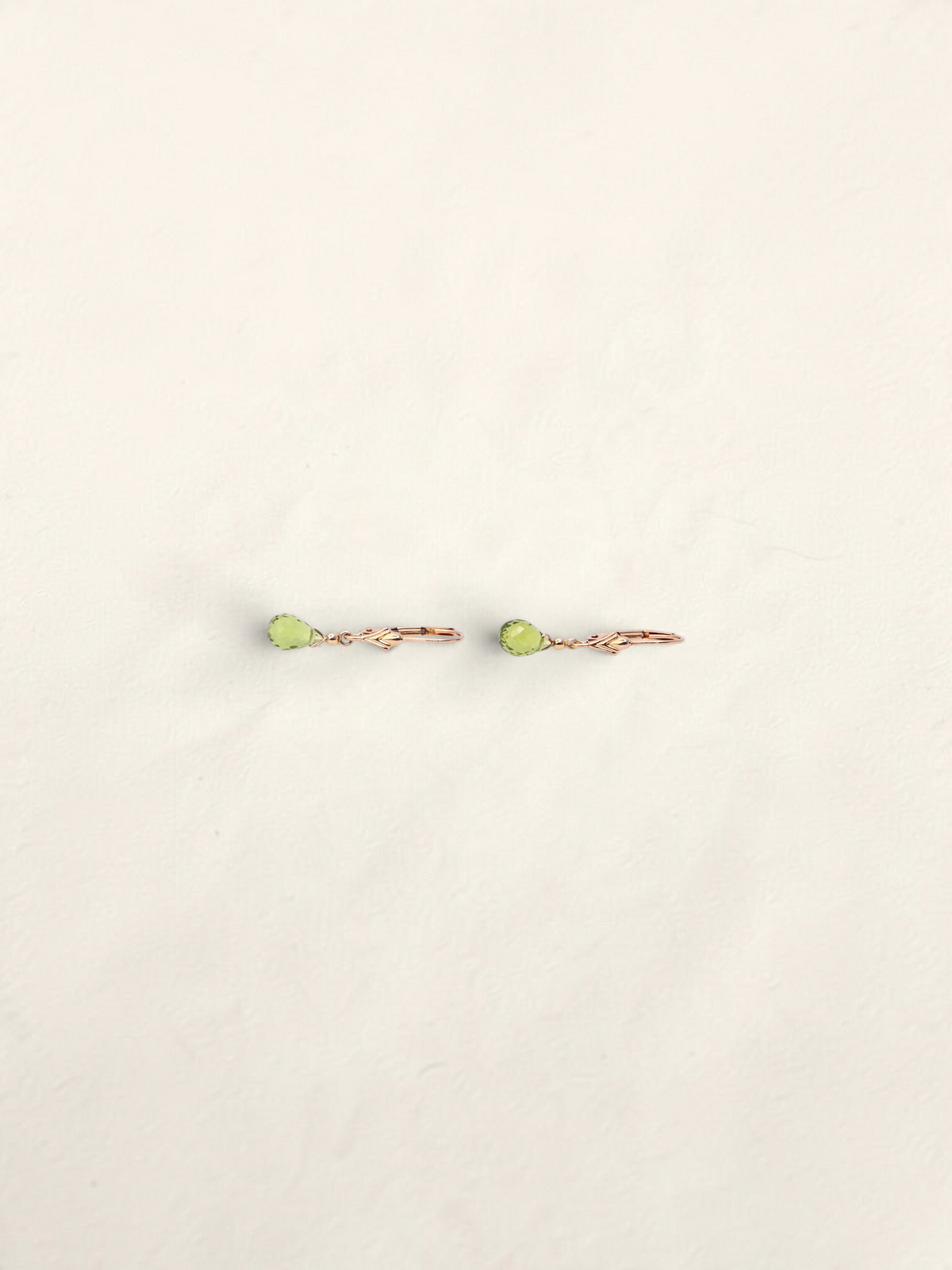 Zafrah 14k yellow gold huggie hoop earrings featuring delicate teardrop-shaped green quartz gemstones.