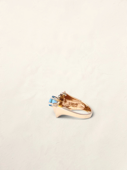 Zafrah 14K yellow gold abstract ring featuring a 1ct round blue topaz stone, side view.