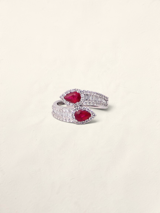 Zafrah 18K white gold bypass ring featuring two pear-cut rubies surrounded by round and baguette-cut diamonds.