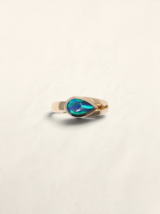 Zafrah 14K yellow gold ring featuring a teardrop-shaped boulder opal inlay with vibrant blue and green flashes.