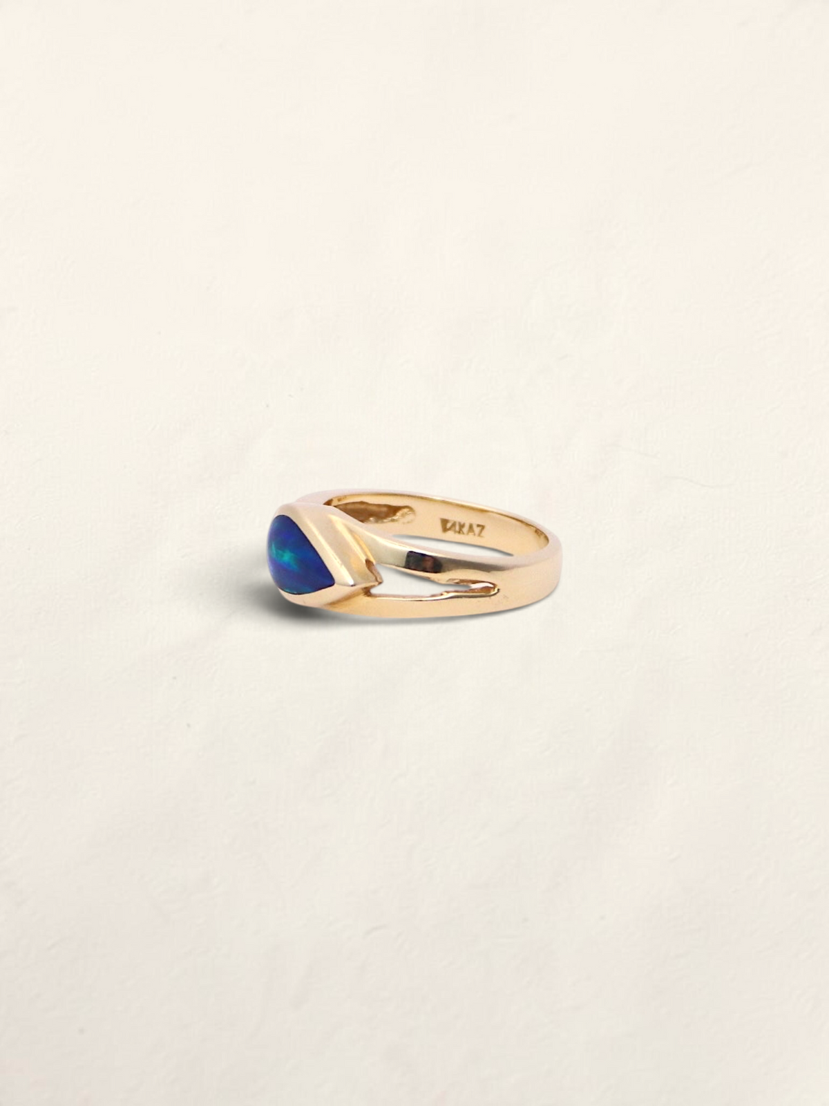 Zafrah 14K yellow gold ring featuring a vibrant blue boulder opal inlay in a sleek, polished band design.