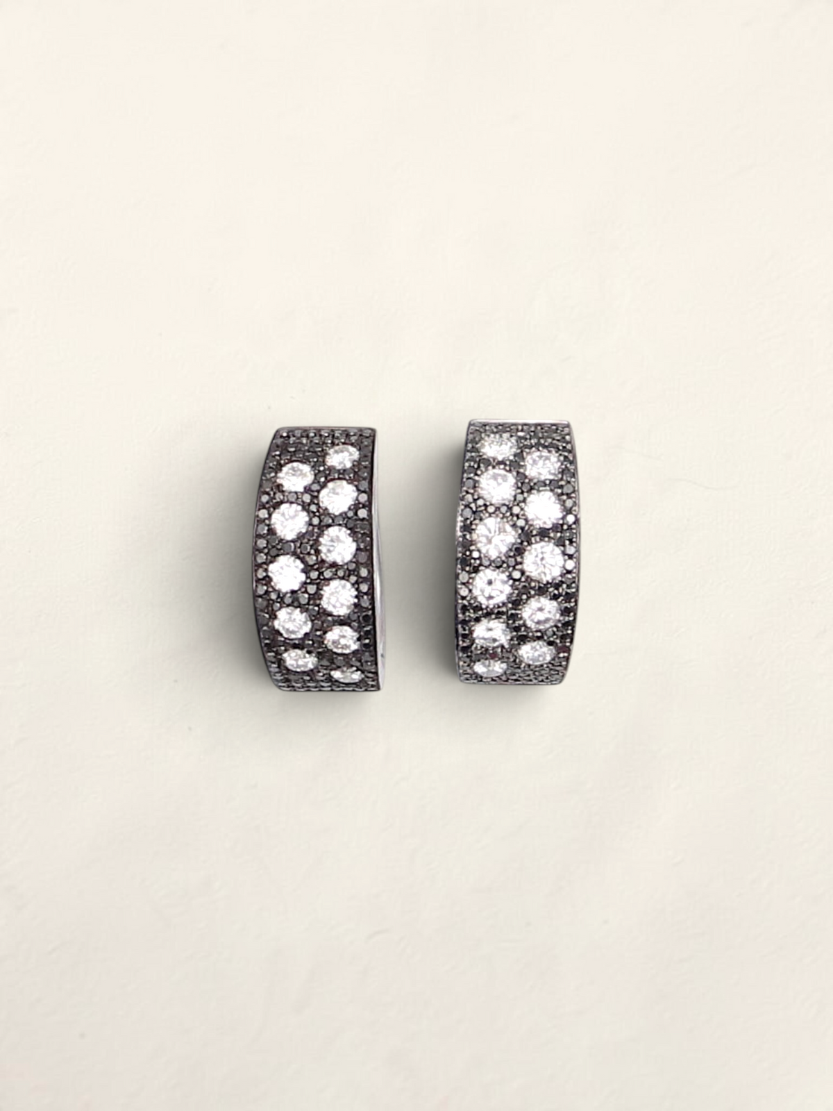 Zafrah 14K white gold huggie hoop earrings featuring a pavé design with round black and white diamonds.