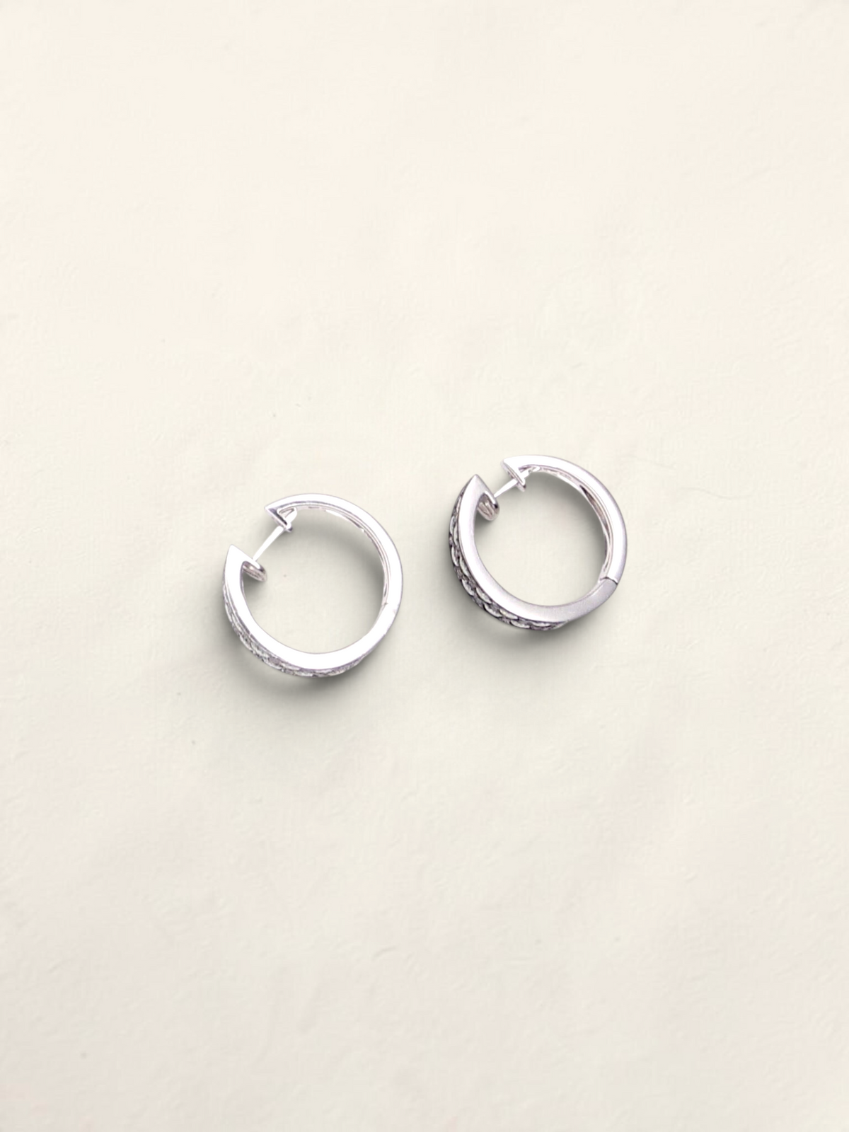 Zafrah 14k white gold huggie hoop earrings featuring a pavé setting of round black and white diamonds.