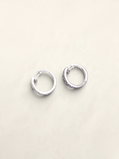Zafrah 14k white gold huggie hoop earrings featuring a pavé setting of round black and white diamonds.