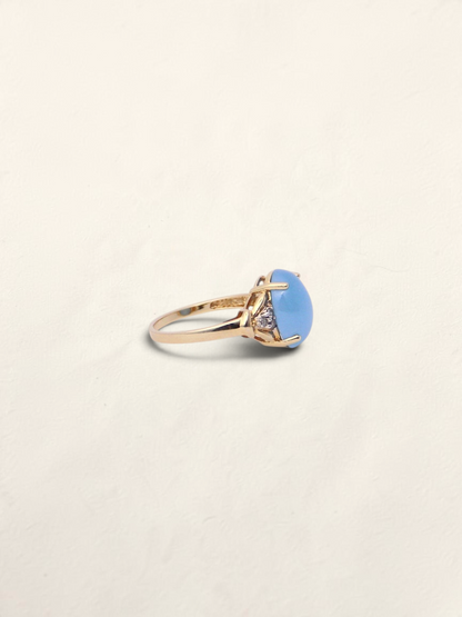 Zafrah 14K yellow gold ring featuring an oval blue jadeite stone accented with round diamonds, side profile view.