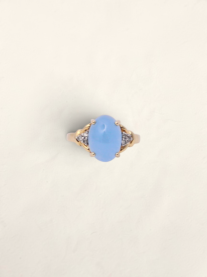 Zafrah 14K yellow gold ring featuring an oval blue jadeite stone flanked by six sparkling round diamonds.