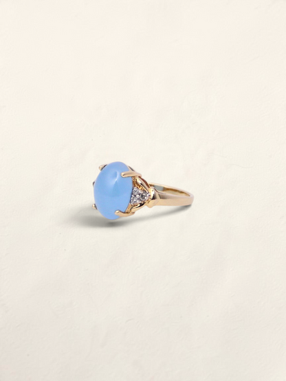Zafrah 14K yellow gold ring featuring an oval blue jadeite cabochon accented with round diamonds.