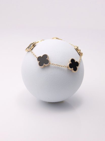 Zafrah 14k yellow gold bracelet featuring five black onyx clover motifs on a delicate chain