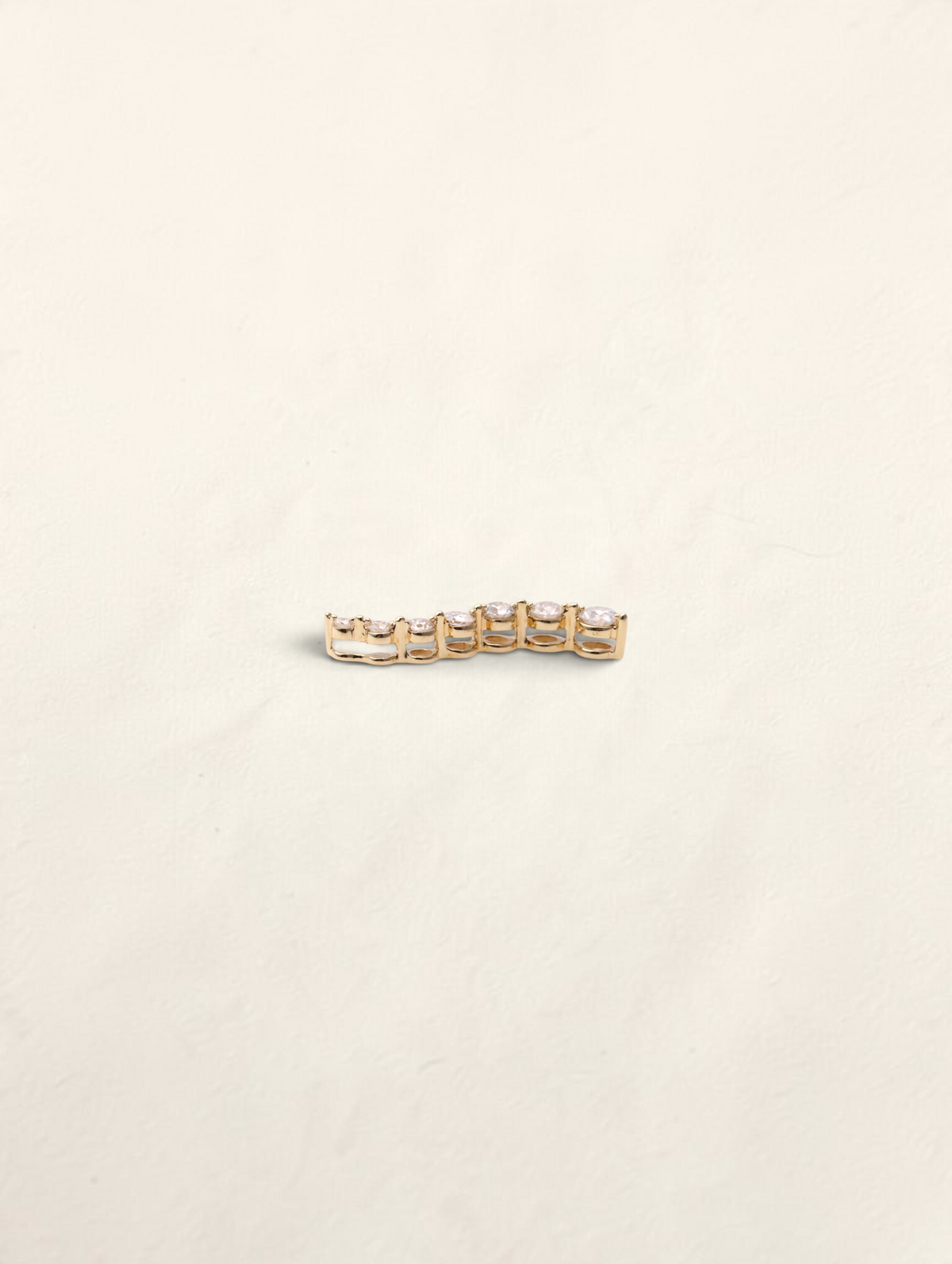 Zafrah 14K yellow gold curved journey pendant featuring seven graduated round diamonds in a prong setting.