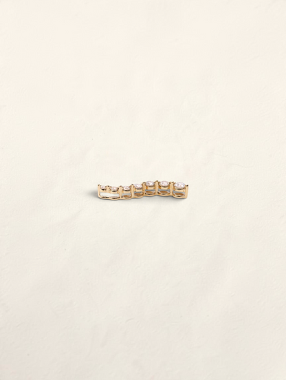 Zafrah 14K yellow gold curved journey pendant featuring seven graduated round diamonds in a prong setting.