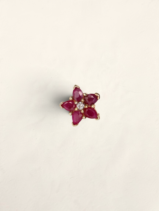 Zafrah 10k yellow gold star pendant featuring five pear-cut rubies and a central round diamond.